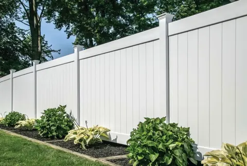 White vinyl privacy fence with landscaping