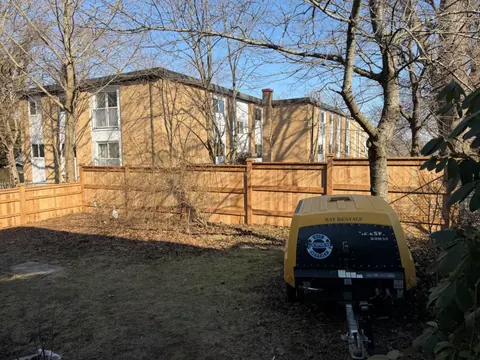 Long wood fence installation behind a property